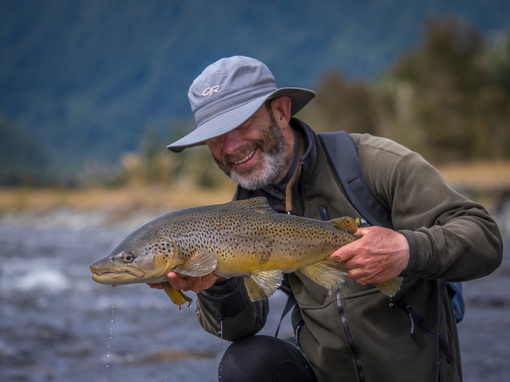 New Zealand angler celebrating fish in backcountry river